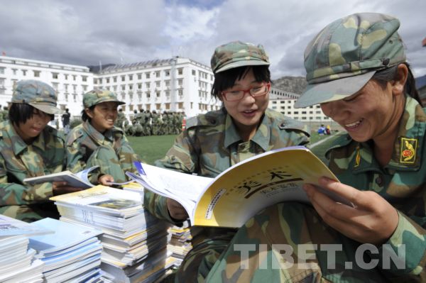 西藏拉萨中学内，正在进行军训的学生领到了新教科书