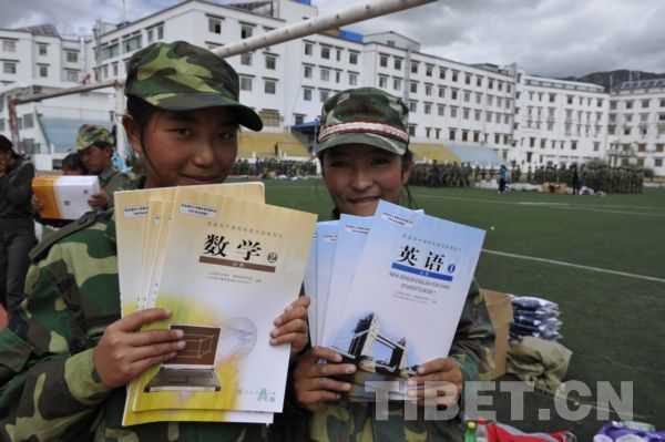 西藏拉萨中学内，正在进行军训的学生领到了新教科书